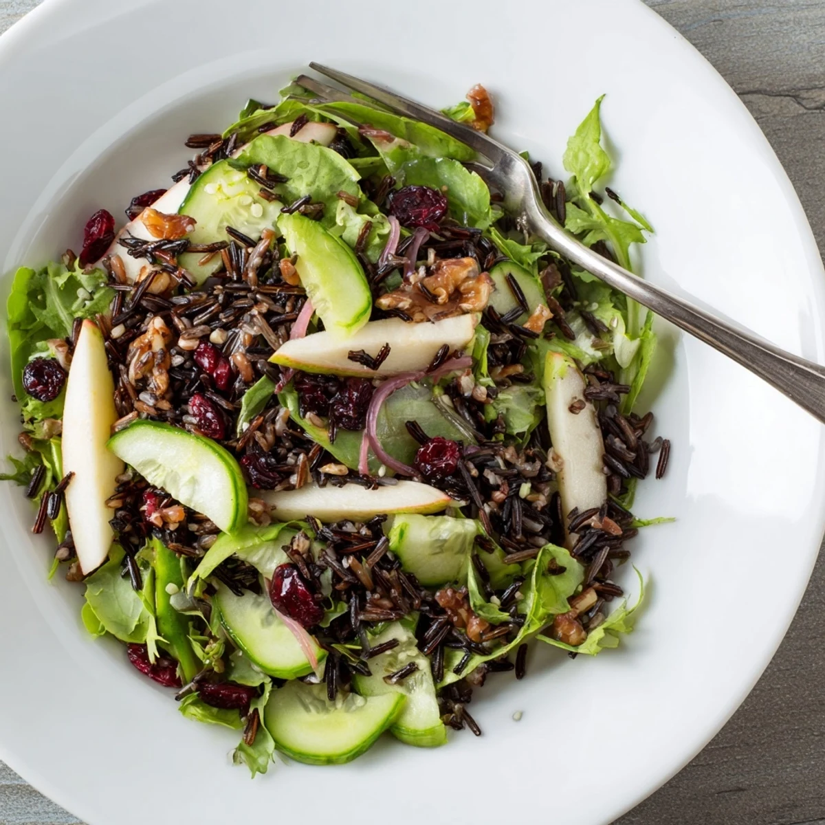 A refreshing close-up of the light forest-inspired wild rice and cranberry salad ingredients tossed in dressing.