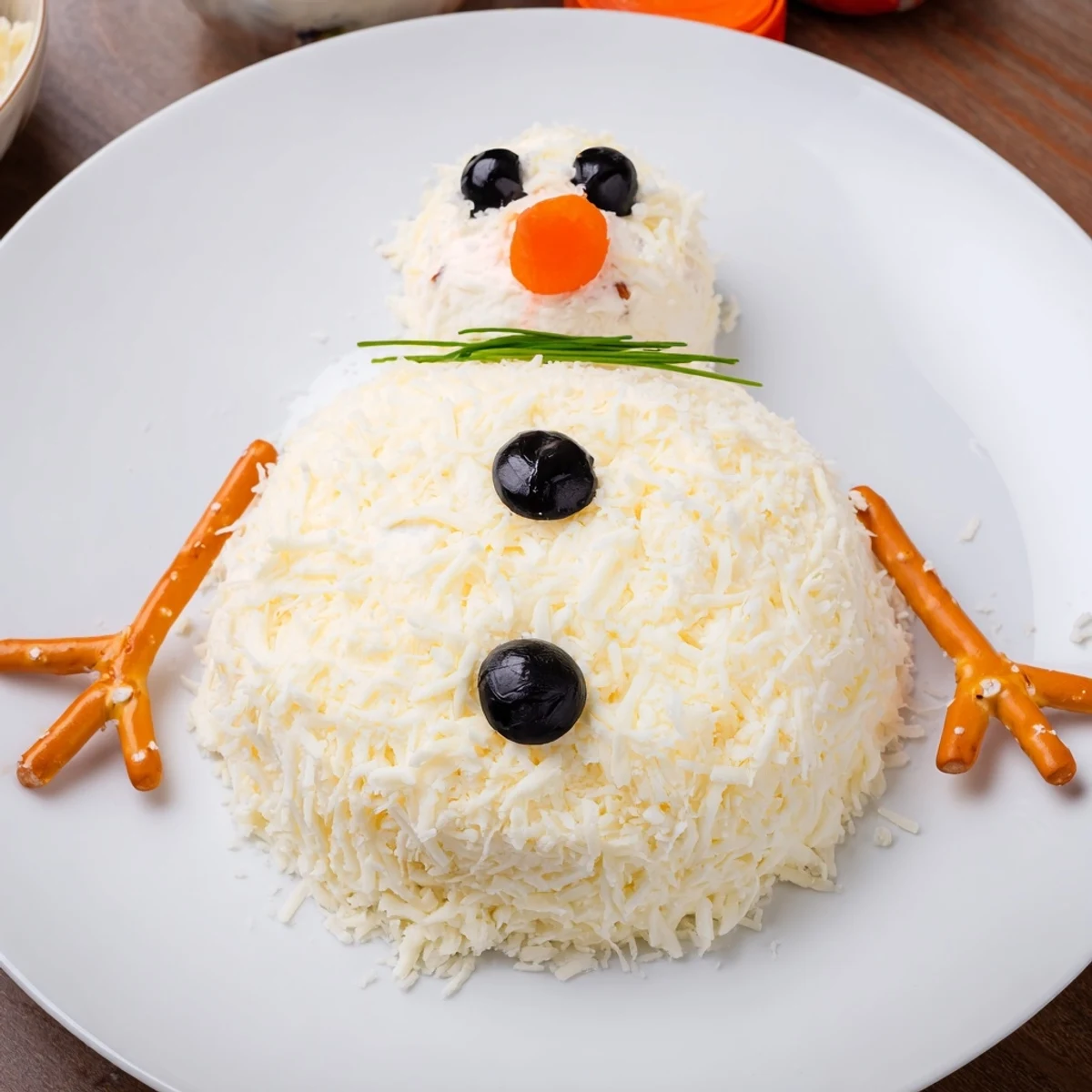 Festive Melted Snowman Cheese Bites appetizer on a platter, ready to be enjoyed with crackers for dipping.