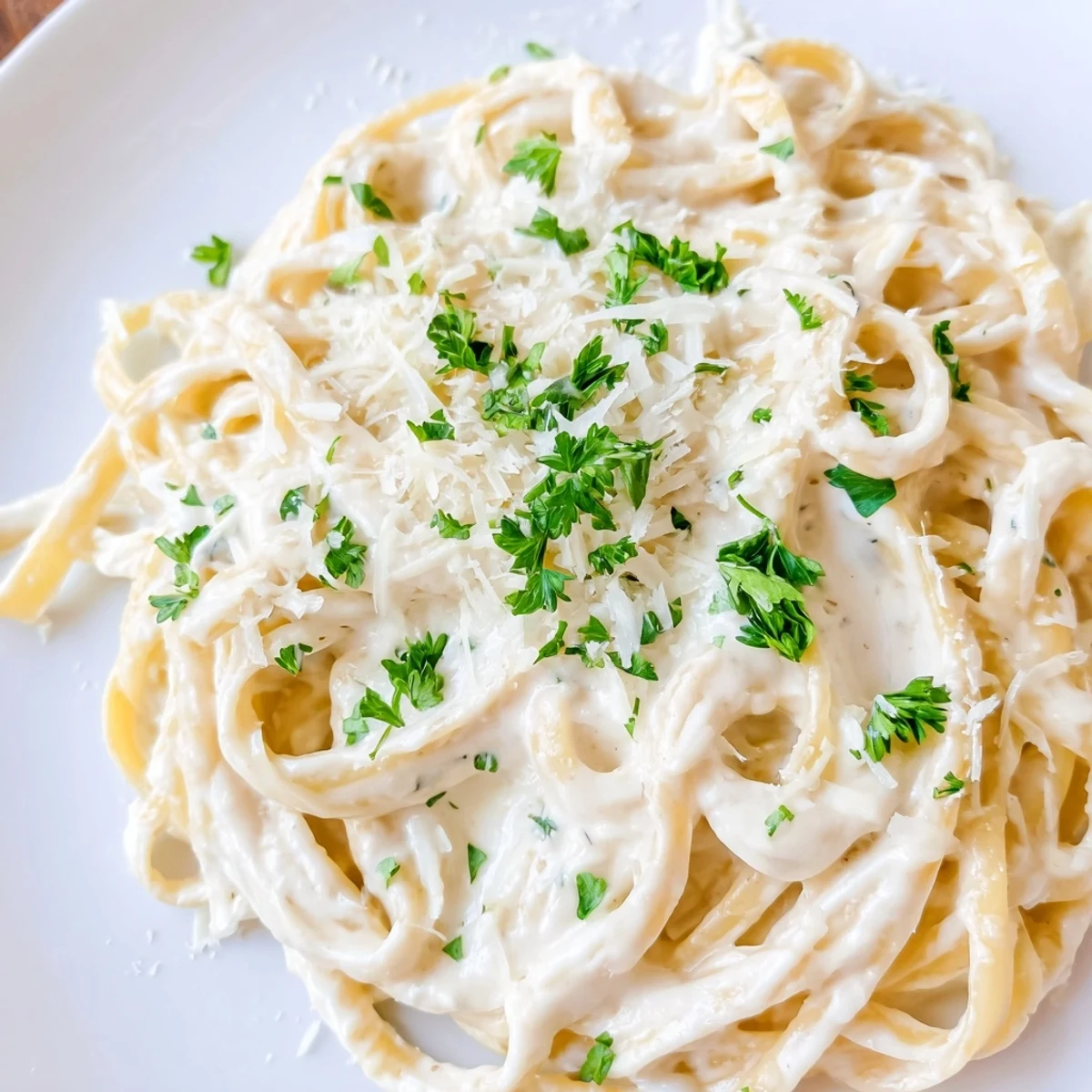 Creamy Cottage Cheese Alfredo Sauce, ready to coat pasta, with fresh parsley garnish sprinkled on top.