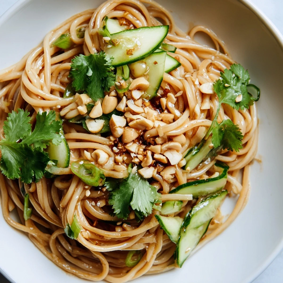 Cold wheat noodles tossed with crisp cucumber slices, fresh cilantro, and toasted sesame seeds in a vibrant sesame-soy-chili dressing.  