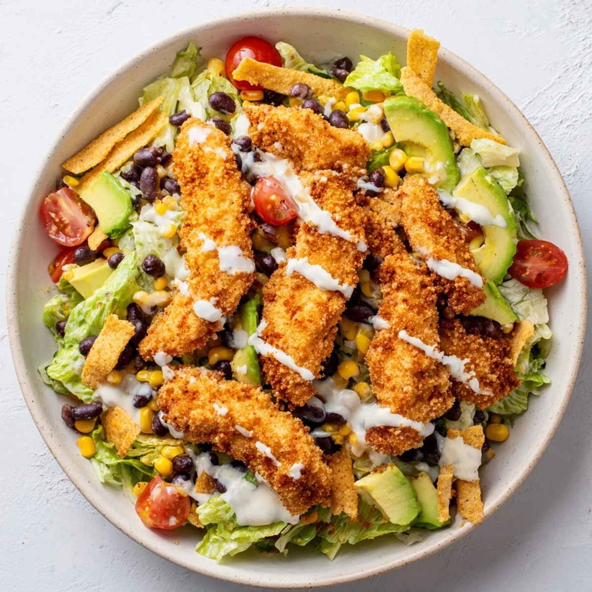Freshly prepared Crispy Chicken Taco Salad featuring diced avocado, cherry tomatoes, and shredded cheddar cheese for a vibrant Tex-Mex lunch.