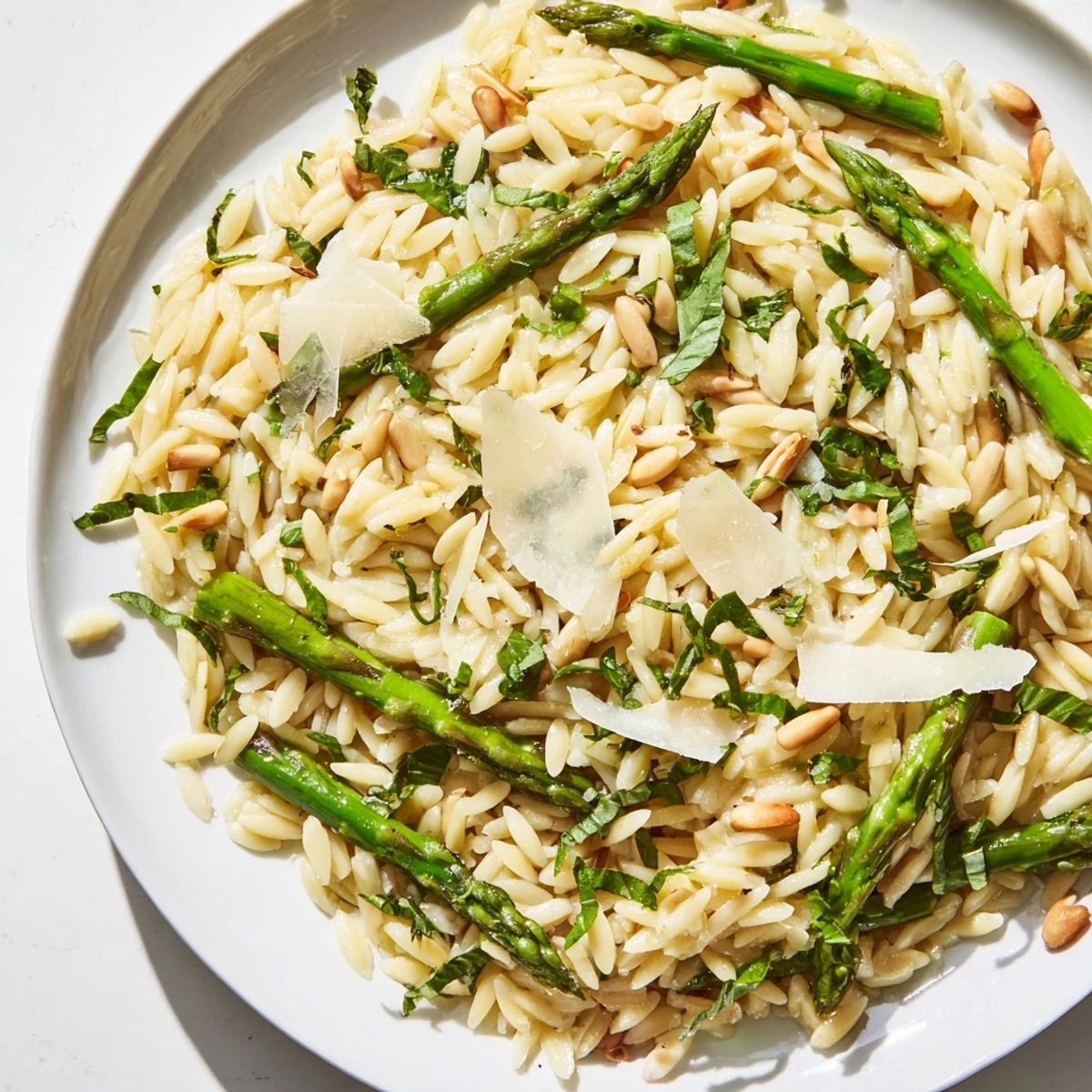 Bright shaved asparagus ribbons and tender orzo pasta mingle with zesty lemon dressing in this vibrant Asparagus Lemon Orzo Salad, topped with toasted pine nuts and fresh herbs.