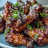 Freshly cooked Coca Cola Chicken Wings steaming on a plate with fluffy white rice, ready for a crowd-pleasing appetizer or main dish.