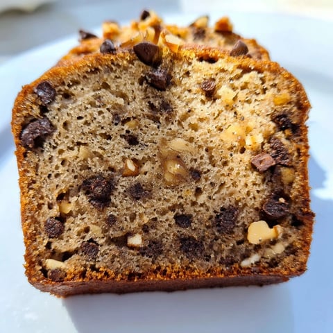 Golden slice of chocolate chip banana bread, showcasing melty chocolate and a soft, moist texture.