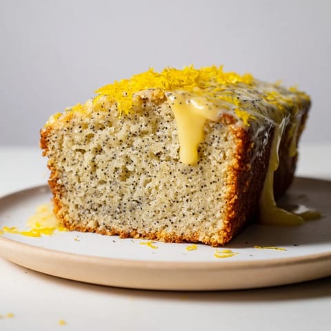 Moist Glazed Lemon Poppy Seed Cake, drizzled with sweet, tangy glaze highlighting its freshness.