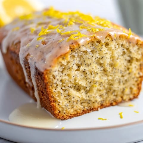 Fluffy slice of Glazed Lemon Poppy Seed Cake, showcasing its tender crumb and bright citrus flavor.