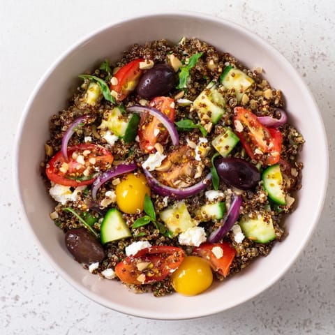 Freshly assembled Mediterranean Grain Bowl, perfect for a light lunch, drizzled with lemon dressing.