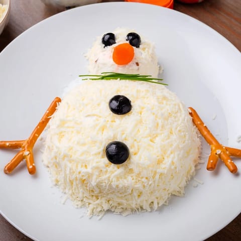 Festive Melted Snowman Cheese Bites appetizer on a platter, ready to be enjoyed with crackers for dipping.