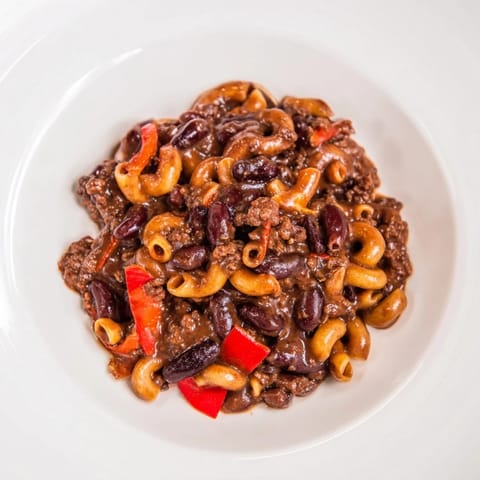 Close-up of hearty one-pot ditalini with hot cocoa chili, showcasing rich, dark sauce and tender pasta.