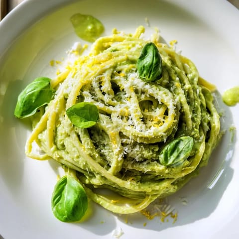 Delicious creamy avocado pasta with bright lemon zest, ready to be enjoyed as a main course.