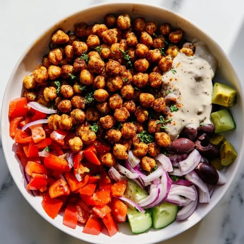 A bright and flavorful Mediterranean Chickpea Bowl: crispy chickpeas next to diced cucumber and tomatoes.