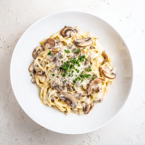 Savory garlic and Parmesan meld in this Creamy Mushroom Alfredo, served steaming in a bowl for a comforting vegetarian dinner.