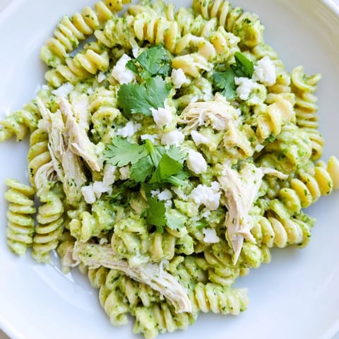 Freshly chopped cilantro and lime wedges garnish this creamy Cilantro Lime Chicken Pasta, perfect for a quick and flavorful weeknight dinner.  