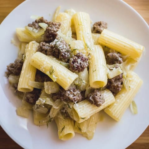 The finished Winter Pasta with Sausage and Fennel in a rustic bowl, garnished with fennel fronds and Parmesan.