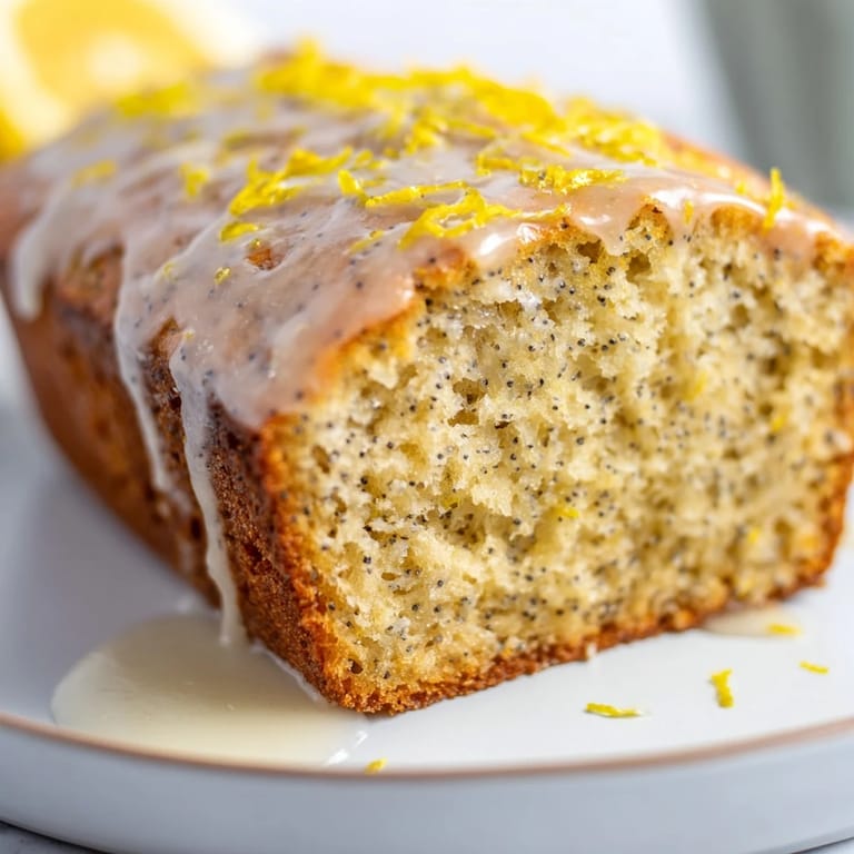 Fluffy slice of Glazed Lemon Poppy Seed Cake, showcasing its tender crumb and bright citrus flavor.