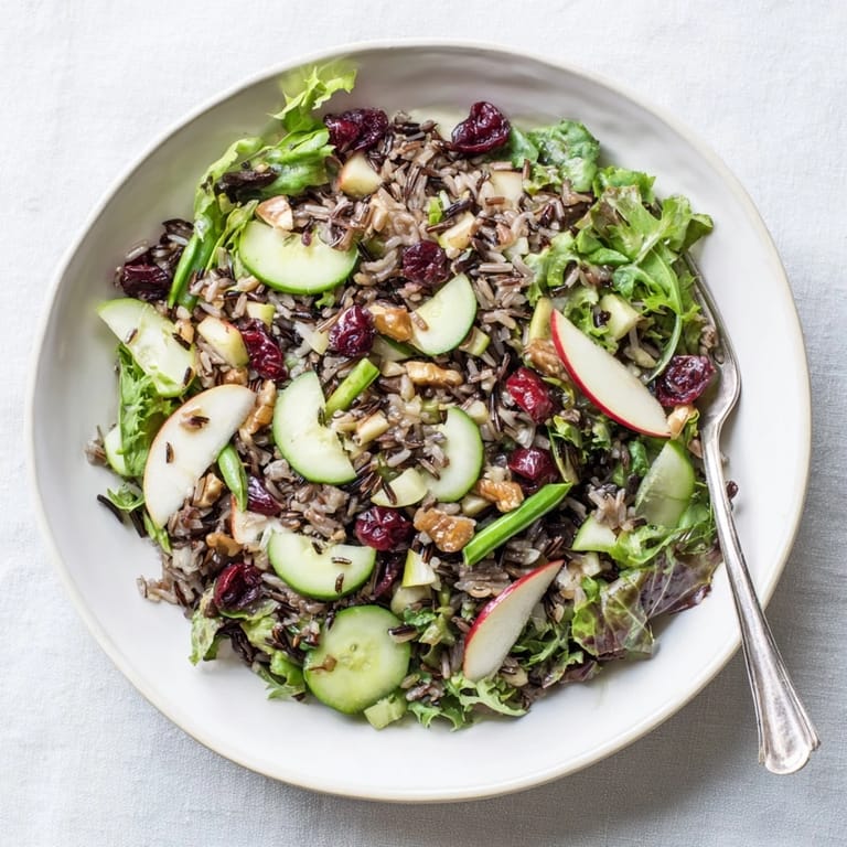 Forest-inspired wild rice and cranberry salad: a beautiful bowl of mixed greens and toasted nuts.