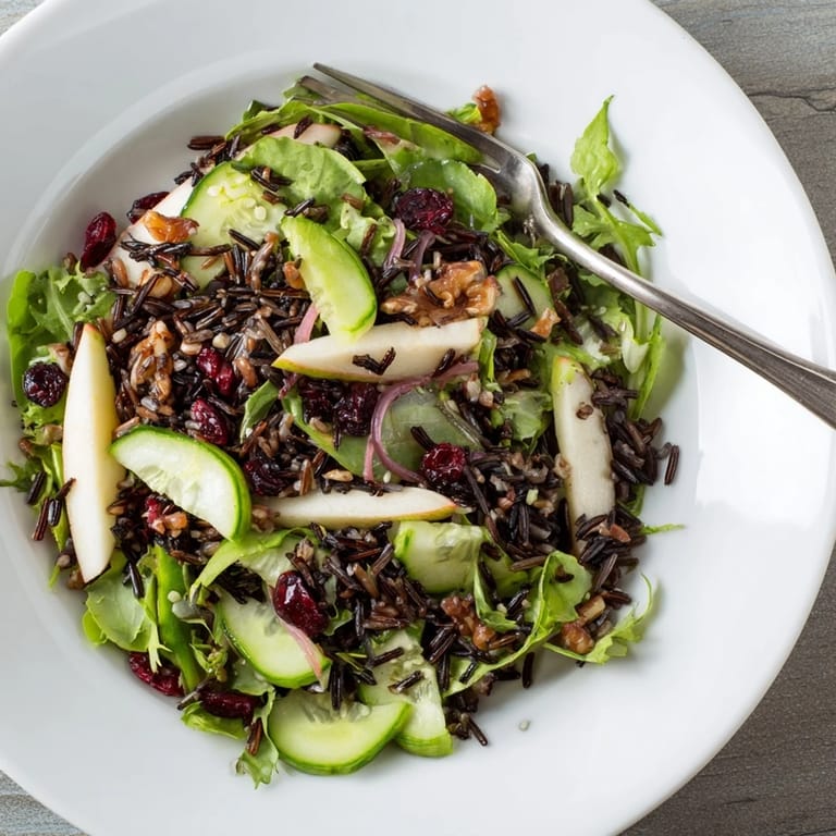 A refreshing close-up of the light forest-inspired wild rice and cranberry salad ingredients tossed in dressing.