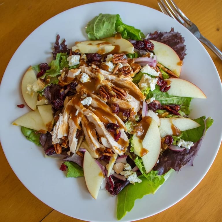 Autumn-inspired Caramel Apple Chicken Salad glistens with maple glaze, candied pecans, and juicy apple slices on a rustic table.