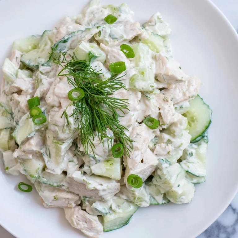 A close-up of Creamy Cucumber Chicken Salad garnished with fresh dill and green onions, ready for a light lunch.