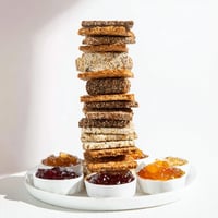Gourmet Crackers displayed in a beautiful tower, served with colorful preserves and fresh fruits.
