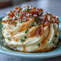 Creamy salted honey butter with fresh thyme and chives, perfect for spreading on warm bread.  
