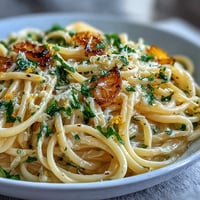 Easy Lemon Butter Pasta in a creamy lemon sauce with fresh parsley and Parmesan on a white plate