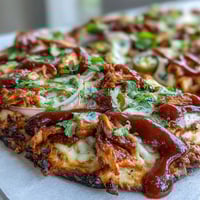 Crispy BBQ chicken flatbread pizza with smoky sauce, melty mozzarella, and fresh cilantro—perfect for a quick dinner.  